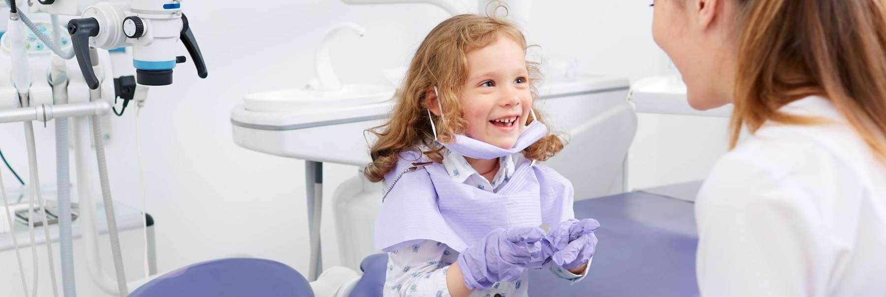 A smiling girl talking to her dentist