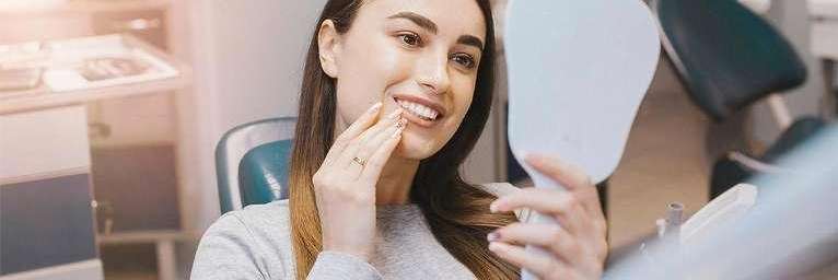 woman examining her recently done veneers