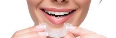 A woman holding a dental mouthguard