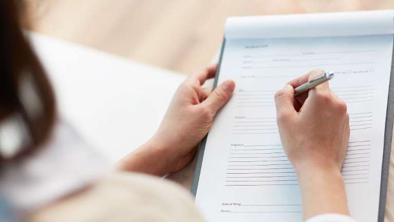 A dental patient filling out a form | superannuation Tamworth