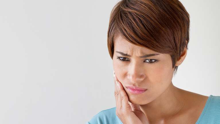 A woman experiencing jaw pain | jaw pain treatment