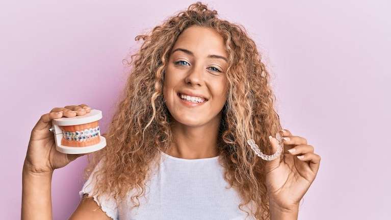 Woman holding a dental model, illustrating orthodontic care for your first visit in Tamworth