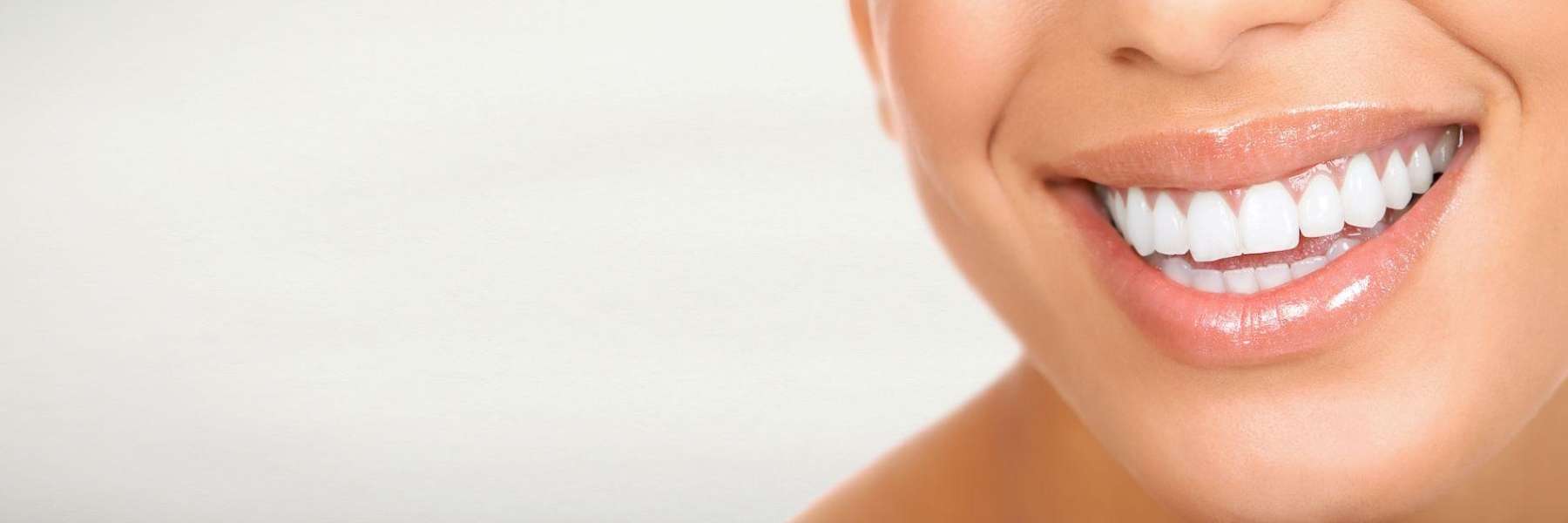 Woman highlights her white teeth, showcasing the benefits of dental health supported by health fund